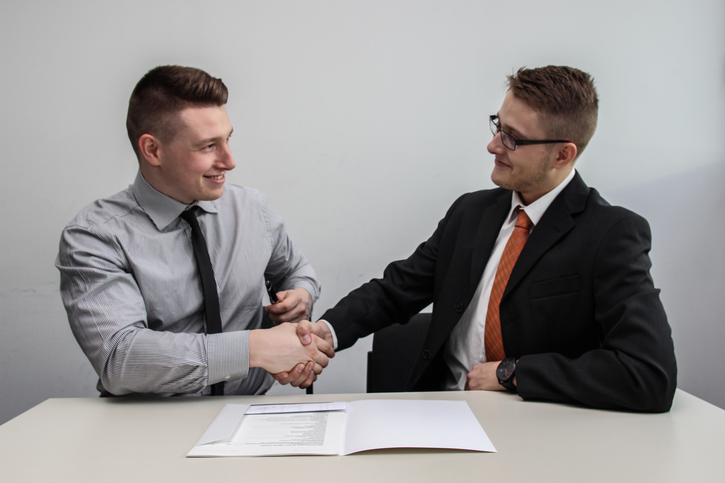 Two men facing each other and shaking hands