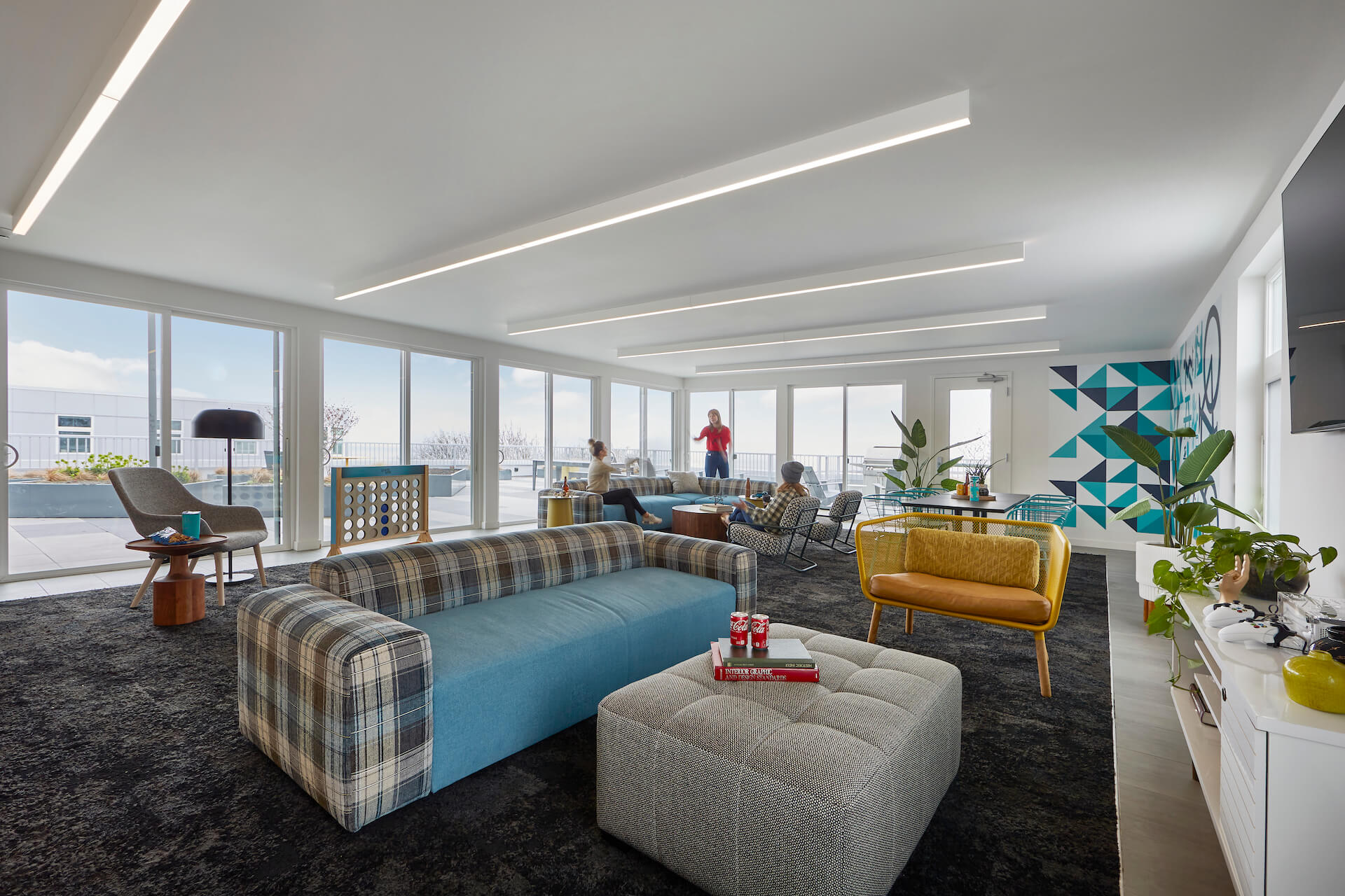 large room with couches, chairs and natural lighting